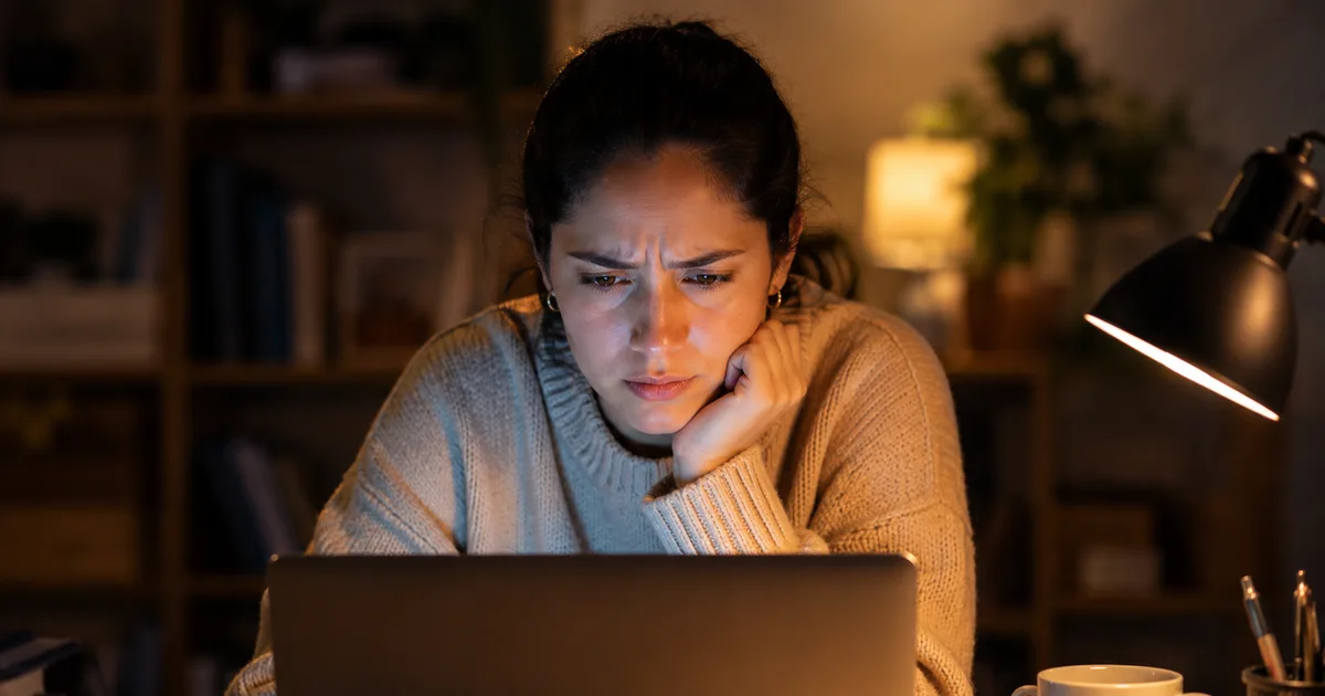 Mujer revisando en su laptop una alerta de error de FirmaEC durante la noche